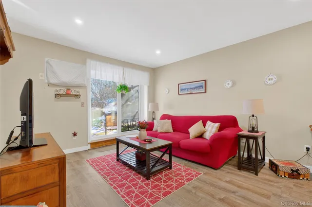 a living room with furniture a flat screen tv and a window
