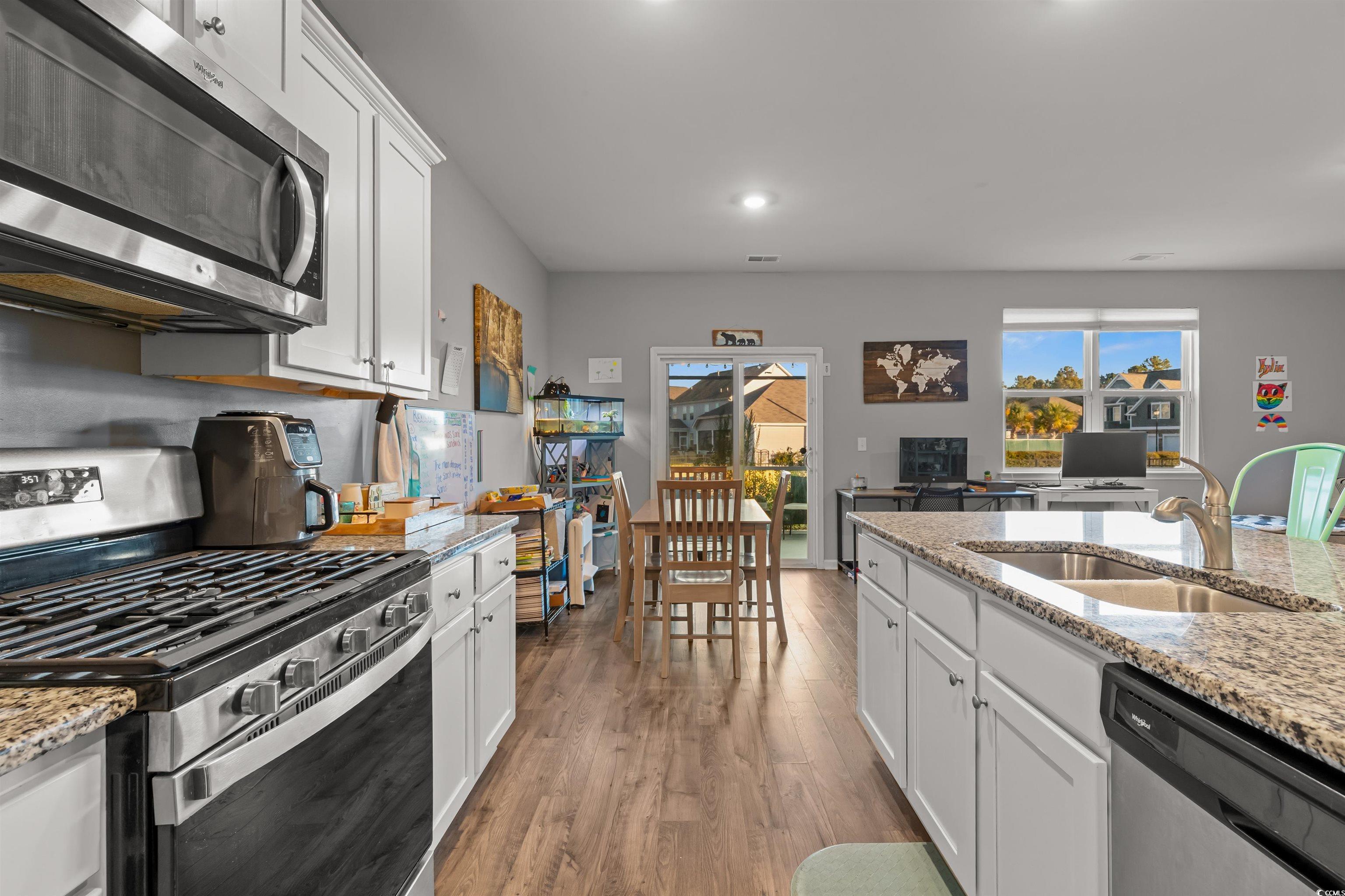 2004 Musgrove Mill Way Myrtle Beach, SC 29579 - Photo 8 of 35 Kitchen featuring white cabinetry, appliances with stainless steel finishes, light stone counters, light wood-type flooring, and recessed lighting