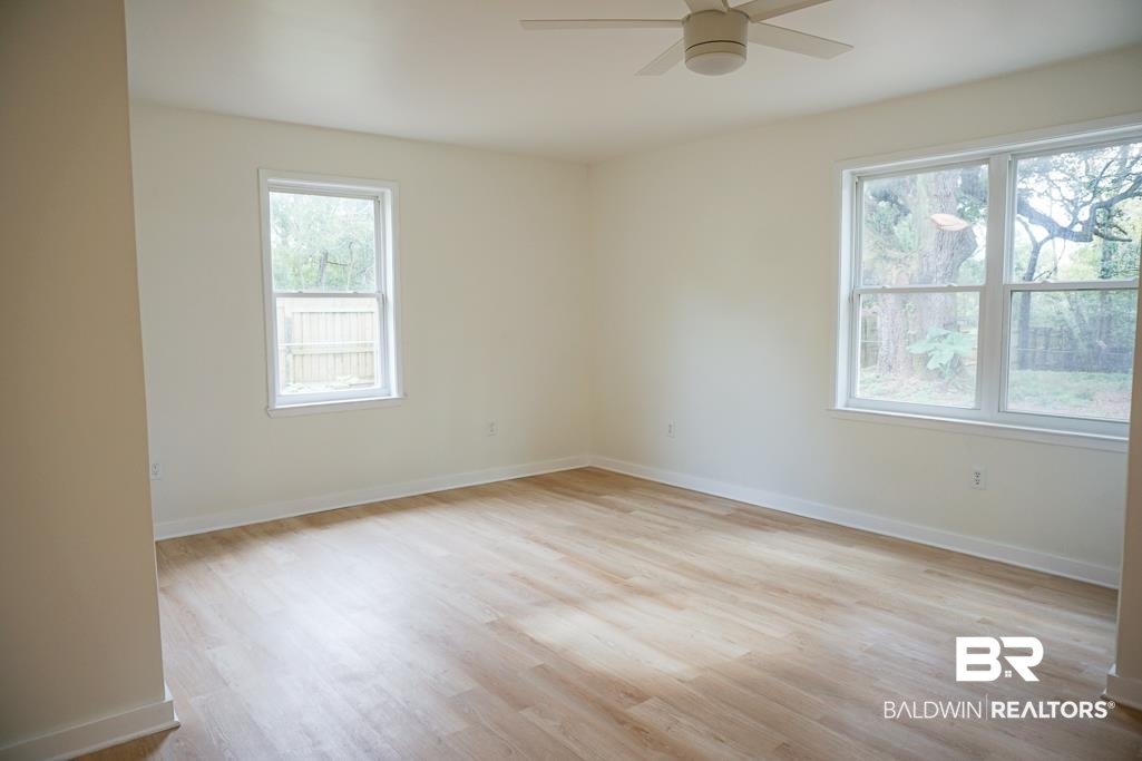 4667 Cottonwood Drive Mobile, AL 36608 - Photo 11 of 21 Empty room featuring ceiling fan, a wealth of natural light, and light hardwood / wood-style flooring