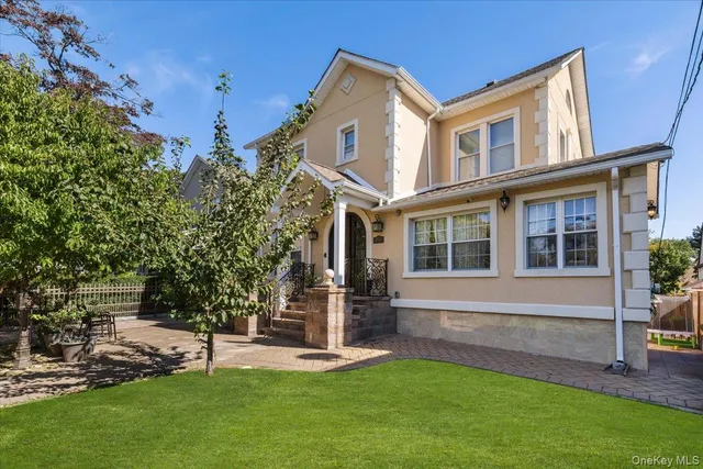 a front view of a house with a yard and trees