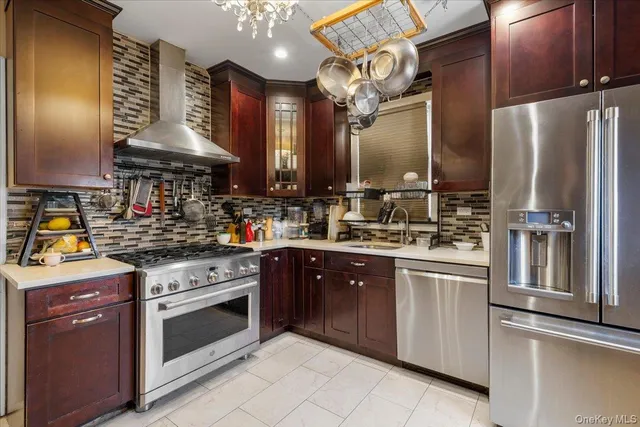 a kitchen with stainless steel appliances granite countertop a sink a stove and a refrigerator