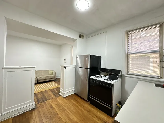a kitchen with a refrigerator and a stove top oven
