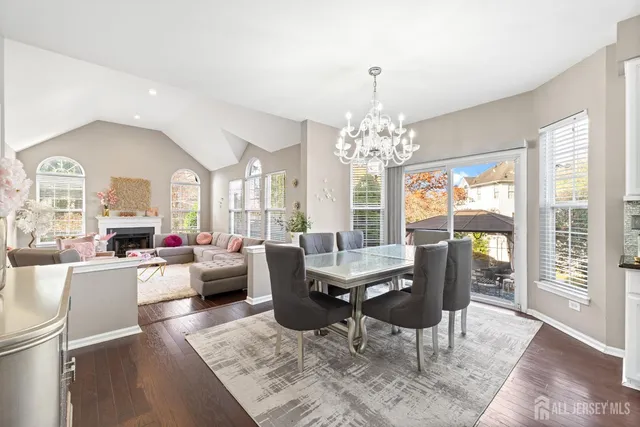 a view of a dining room with furniture a chandelier and wooden floor
