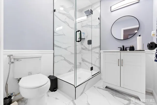 a bathroom with a toilet a sink and mirror