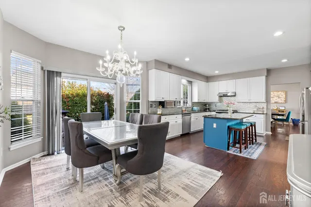 a dining room with wooden floor and a chandelier