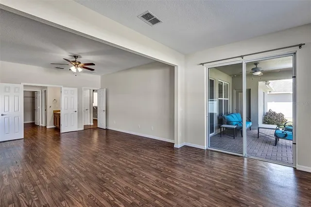 a view of a livingroom with wooden floor and a ceiling fan