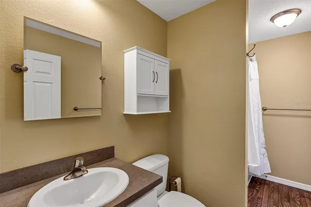 a bathroom with a toilet sink and mirror