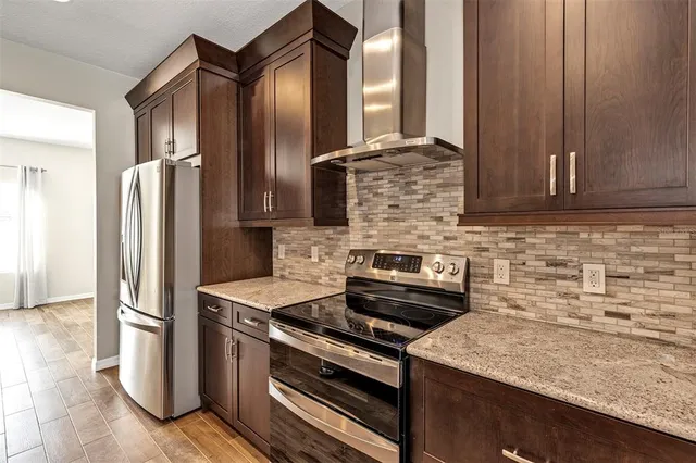 a kitchen with stainless steel appliances granite countertop a refrigerator and a stove