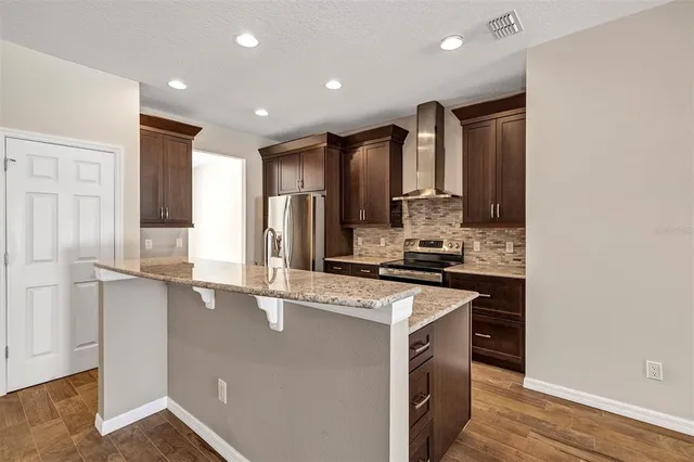 a kitchen that has a sink a stove and a refrigerator