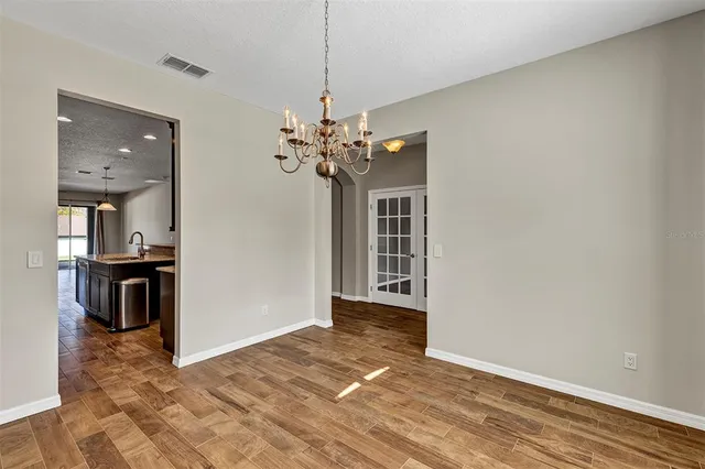 a view of a livingroom with a kitchen space with wooden floor