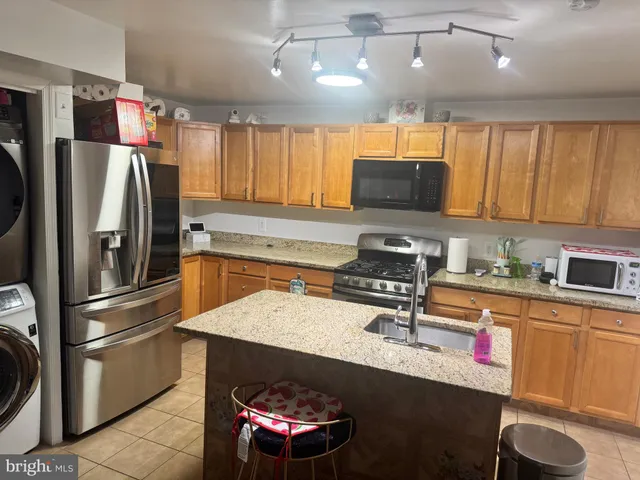 a kitchen with granite countertop a refrigerator stove and sink