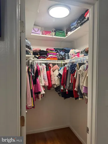 a view of walk in closet with clothes