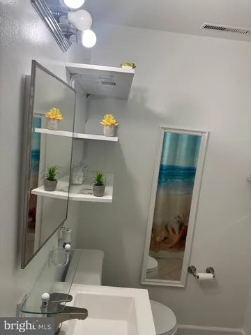 a bathroom with a toilet and a mirror