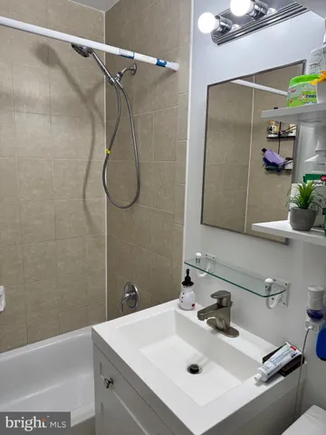 a bathroom with a sink mirror and shower