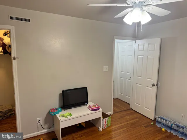 a view of a hallway with wooden floor and closet