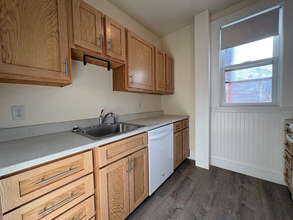 7 Scottfield Road, Unit 8 Boston, MA 02134 - Photo 4 of 6 a kitchen with stainless steel appliances granite countertop white cabinets and window
