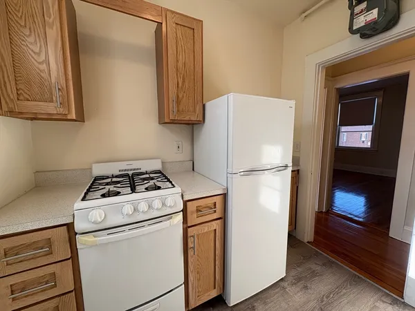 a white refrigerator freezer and a stove sitting inside of a kitchen