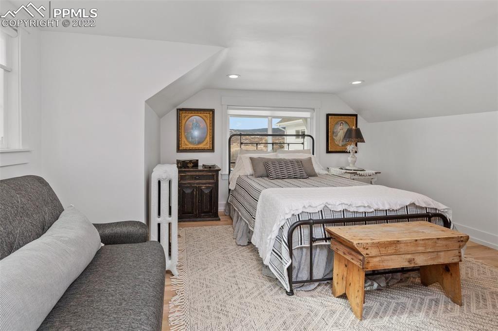 2073 North Perry Park Road Sedalia, CO 80135 - Photo 18 of 40 a spacious bedroom with a bed a couch and a chandelier