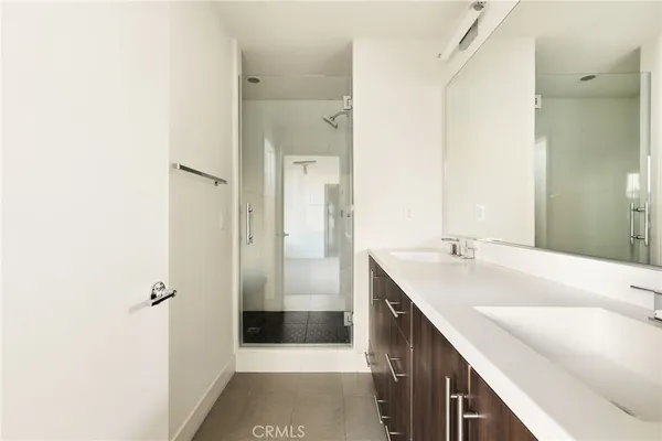 a bathroom with a double vanity sink a mirror and a shower