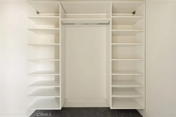 a view of walk in closet with empty racks