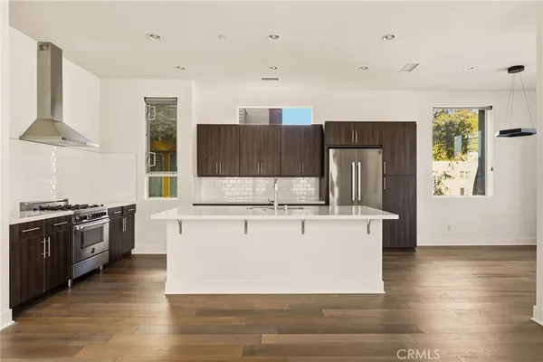 a kitchen with stainless steel appliances wooden floors and wooden cabinets