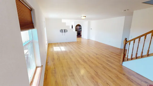 a view of a hallway with wooden floor and a window