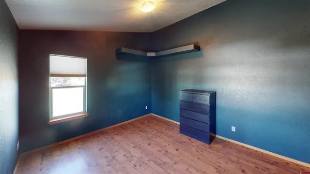 an empty room with windows and wooden floor