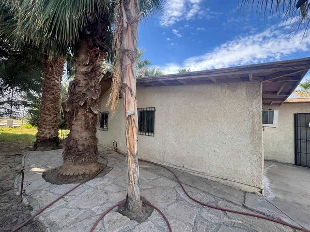 a backyard of a house with table and chairs