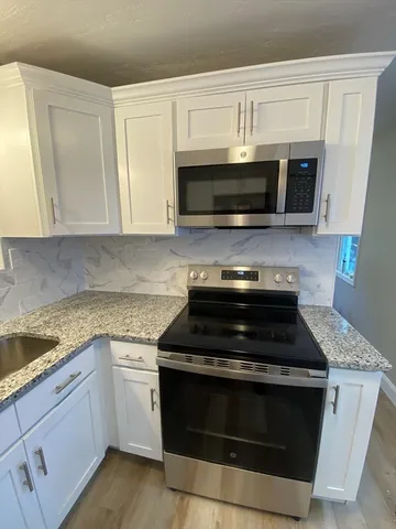 a kitchen with granite countertop a refrigerator and a sink