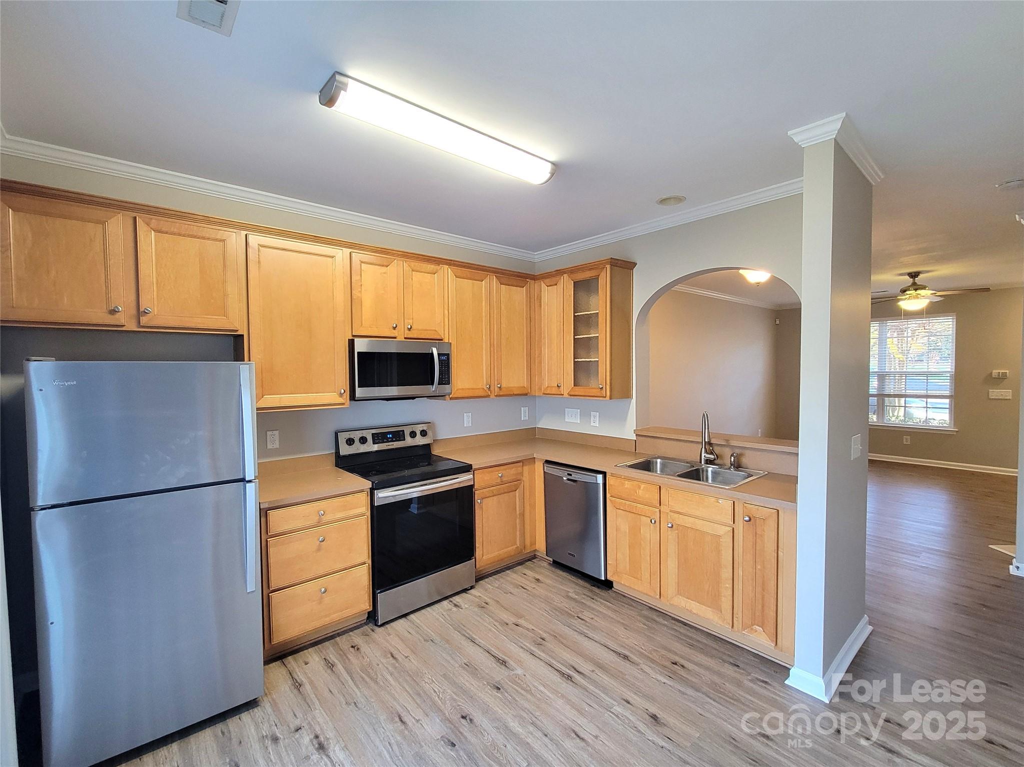 1036 Tabard Lane Matthews, NC 28104 - Photo 4 of 13 a kitchen with stainless steel appliances granite countertop white cabinets a refrigerator a stove a sink and a microwave