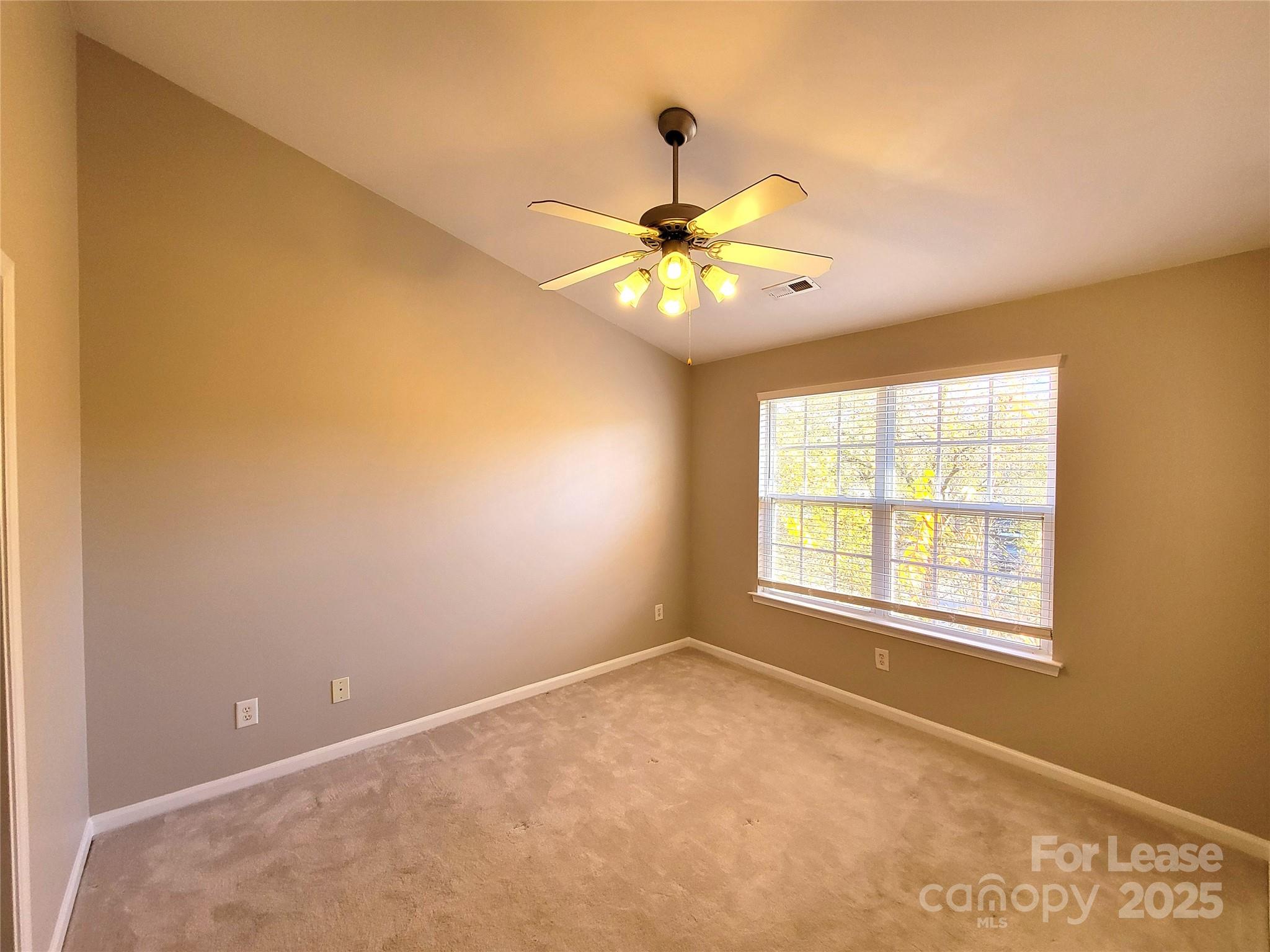 1036 Tabard Lane Matthews, NC 28104 - Photo 5 of 13 an empty room with a window and a ceiling fan