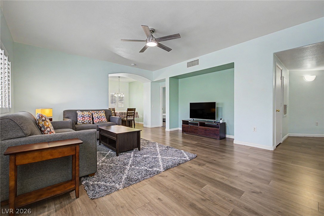 2153 Quarry Ridge Street, Unit 103 Las Vegas, NV 89117 - Photo 12 of 42 Step into a sun-filled living space featuring attractive wood flooring and a modern ceiling fan.