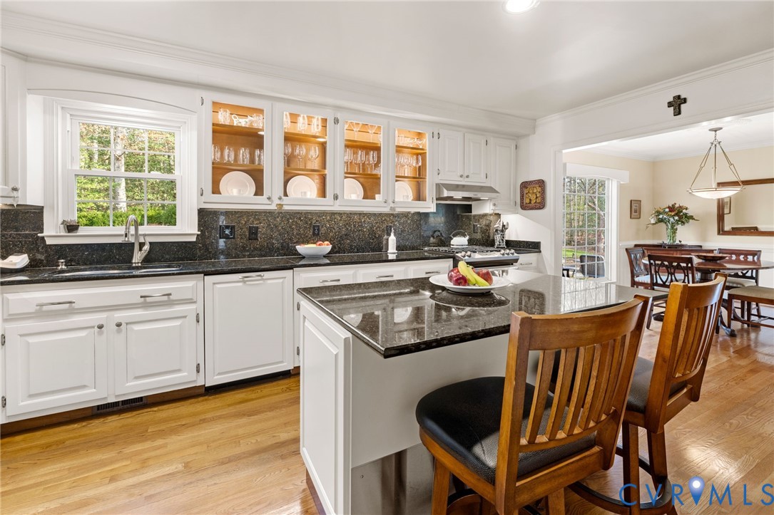 1530 Greenberry Road Powhatan, VA 23139 - Photo 19 of 49 a kitchen with stainless steel appliances granite countertop a stove a sink dishwasher a dining table and chairs with wooden floor