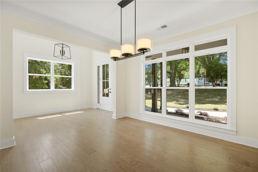 100 Garden Gate Drive Anderson, SC 29621 - Photo 6 of 43 This bright room features abundant natural light, hardwood flooring, and elegant crown molding, creating an inviting atmosphere.