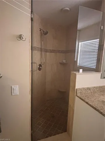 a bathroom with a granite countertop shower and vanity