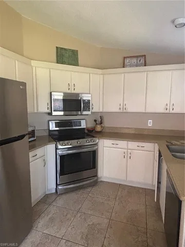 a kitchen with cabinets stainless steel appliances and a counter space
