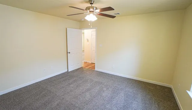 an empty room with closet and windows