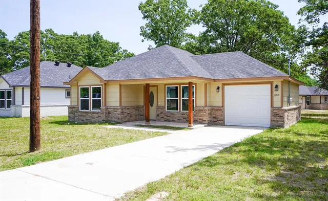 a front view of a house with a yard and porch