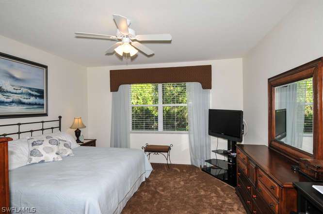 4688 Fairloop Lehigh Acres, FL 33973 - Photo 13 of 24 a bedroom with a bed and a flat screen tv