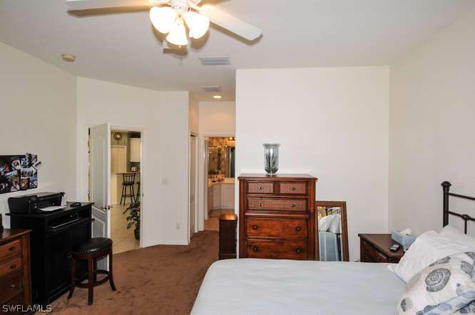 4688 Fairloop Lehigh Acres, FL 33973 - Photo 14 of 24 a bedroom with a bed and furniture