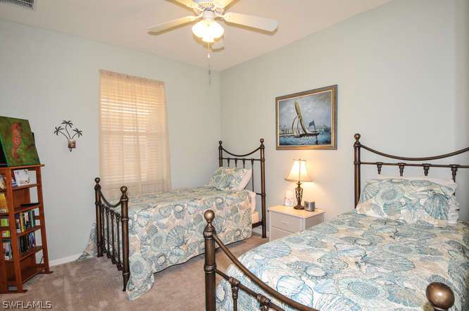 4688 Fairloop Lehigh Acres, FL 33973 - Photo 16 of 24 a bedroom with a bed and a chandelier