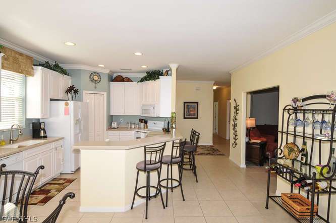 4688 Fairloop Lehigh Acres, FL 33973 - Photo 2 of 24 a kitchen with stainless steel appliances a table and chairs in it
