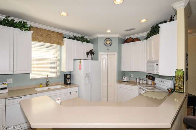 4688 Fairloop Lehigh Acres, FL 33973 - Photo 3 of 24 a kitchen with a sink a counter top space and appliances