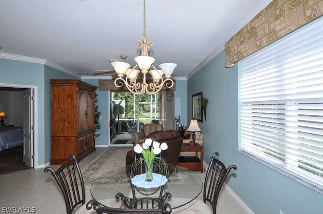4688 Fairloop Lehigh Acres, FL 33973 - Photo 7 of 24 a dining room filled chandelier and kitchen view
