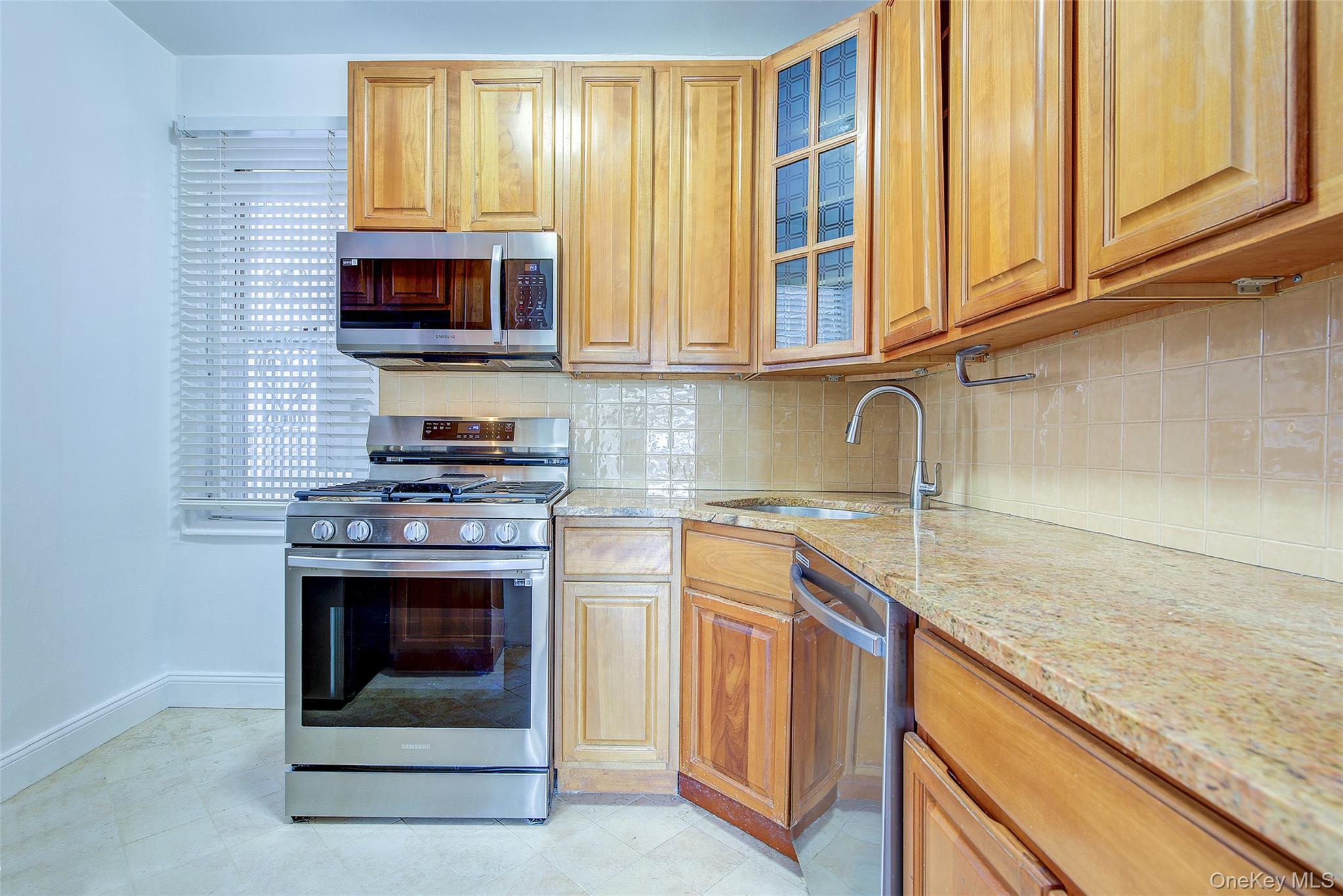 77-14 113th Street, Unit 4S Queens, NY 11375 - Photo 17 of 40 a kitchen with stainless steel appliances granite countertop a sink stove and microwave