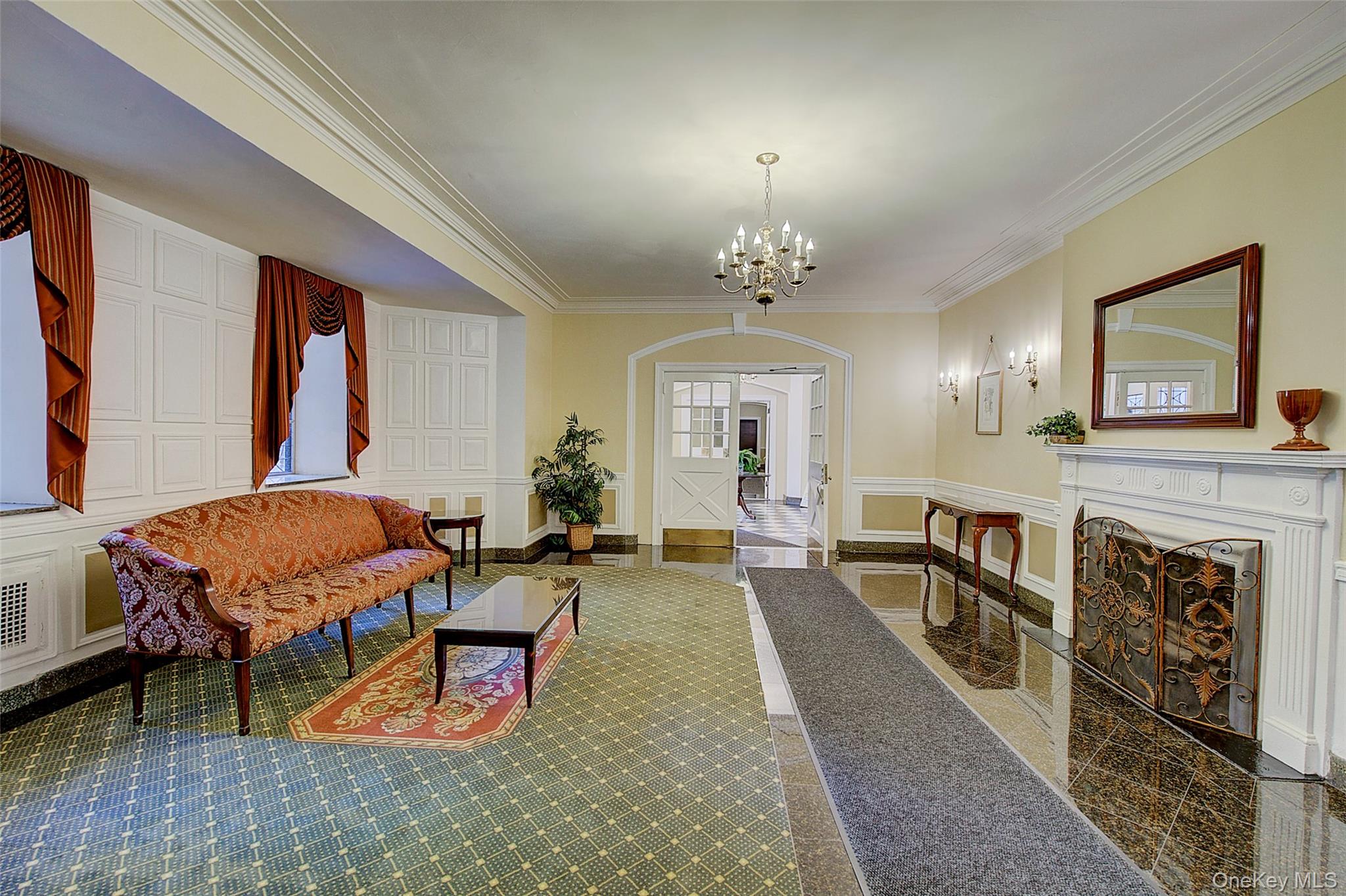 77-14 113th Street, Unit 4S Queens, NY 11375 - Photo 4 of 40 a living room with furniture a chandelier a fireplace and a window