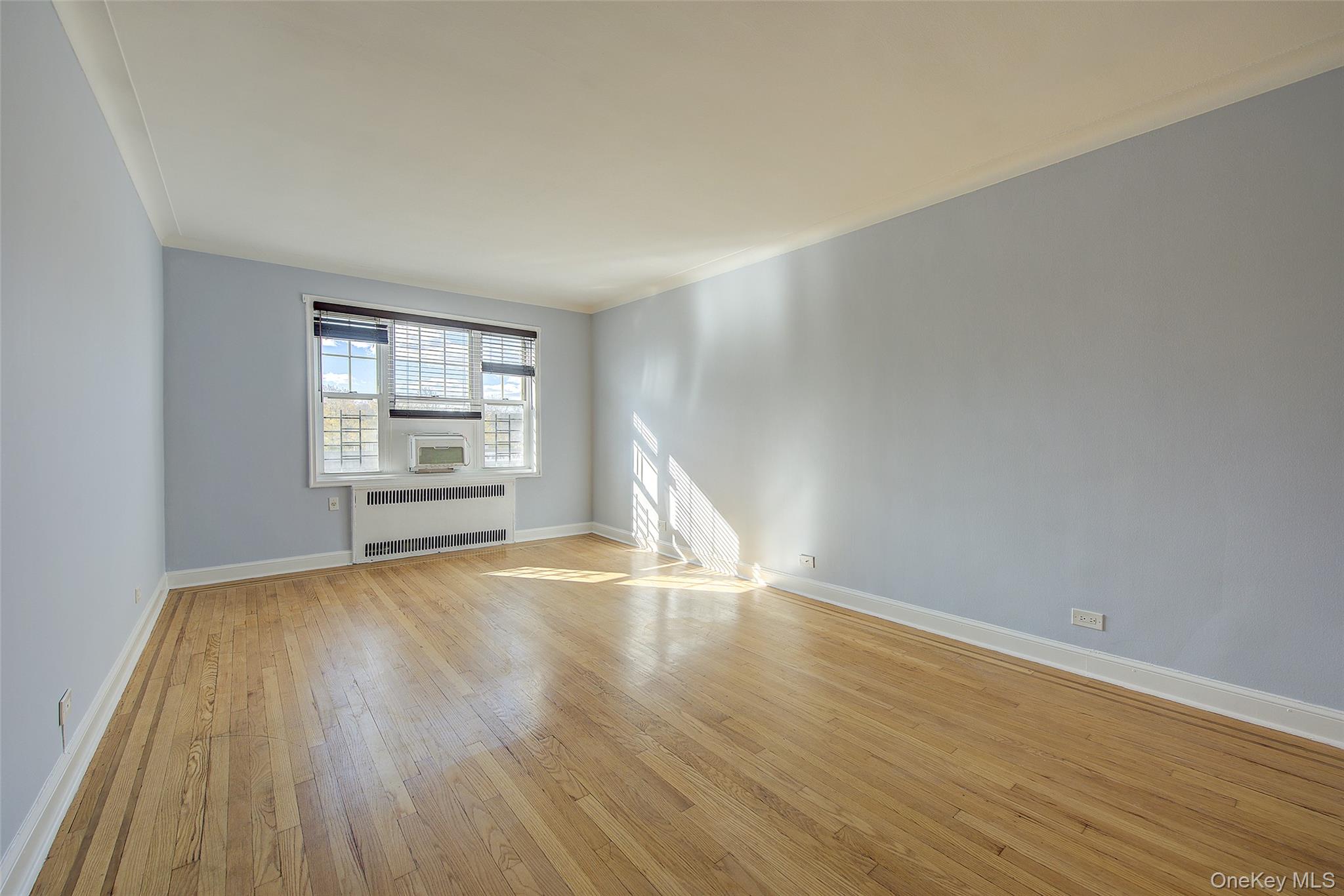 77-14 113th Street, Unit 4S Queens, NY 11375 - Photo 6 of 40 wooden floor in an empty room with a window