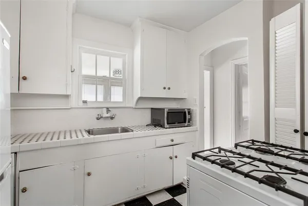 a kitchen with white cabinets and appliances