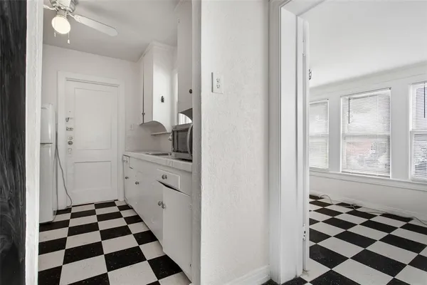 a kitchen with a checkered floor and white cabinets