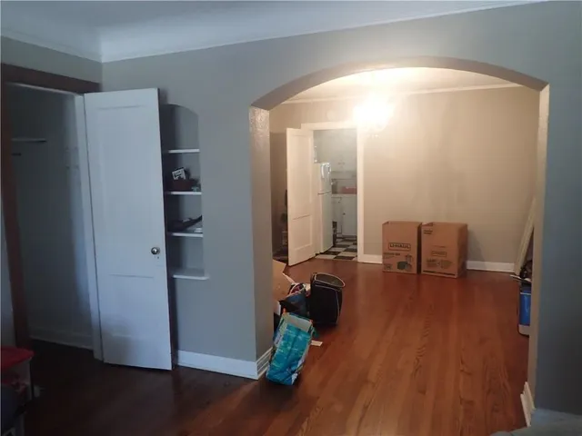 an empty room with wooden floor and furniture